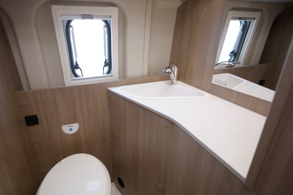 Carado motorhome bathroom with washbasin, mirror, toilet and window