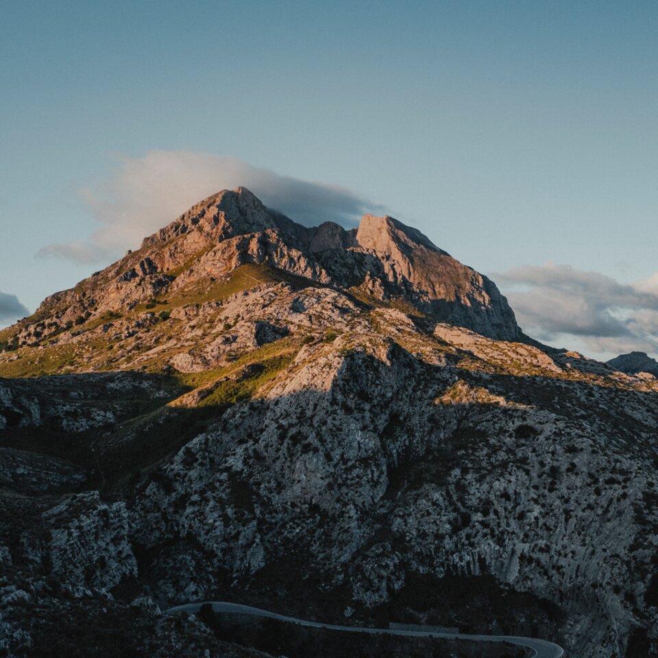 Vue de l'avant sur le Venture S, avec le toit relevé, des montagnes et de l'eau en arrière-plan.